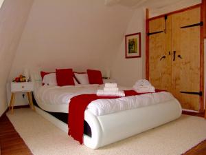 萨尔拉拉卡内达FRANRÉAL, 4 Appartements的卧室配有带红色枕头的大型白色床