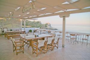 埃利亚·拉克尼亚斯Elea Mare的一间带桌椅的海景餐厅