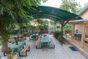 叶索哈马拉勒亚哈斯穆拉度假屋的户外庭院设有绿色桌子和长椅
