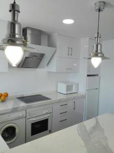 阿尔姆尼卡Apartamento Cotobro的厨房配有白色橱柜和炉灶烤箱。