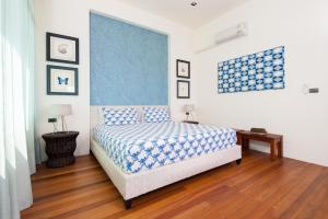 涛岛Overthemoon Luxury Pool Villas的一间卧室配有一张带蓝白色毯子的床