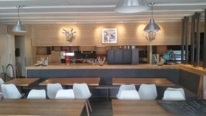 莱莫斯阿尔平驿站酒店的用餐室配有木桌和白色椅子