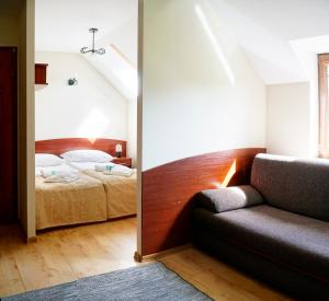 齐莱涅克Ski&Spa Zieleniec的一间卧室配有一张床和一个沙发