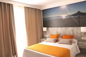 多列毛利诺斯Apartamentos Casa Florido的一间卧室配有一张带橙色枕头的大床