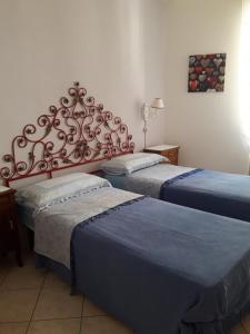因佩里亚La bomboniera的一间设有两张蓝色床单的床的房间