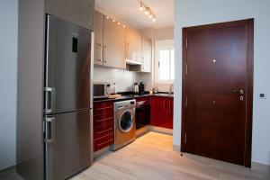 阿达莱斯Apartamento Vadim的厨房配有不锈钢冰箱和红色橱柜