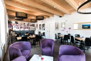 多索博诺欧佩拉酒店的一间设有紫色桌椅的餐厅和一间酒吧