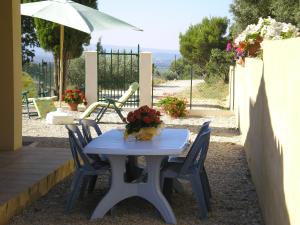 Le BarrouxLes Cigales du Ventoux的一张带椅子的蓝色桌子和一把雨伞