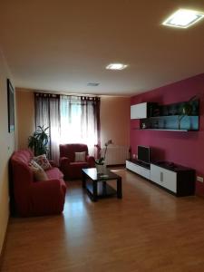 阿尔苏阿Castelao Apartments的客厅配有红色的沙发和桌子