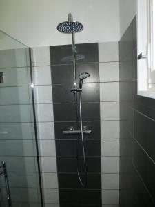 Puch-dʼAgenais莫兰城堡旅馆的浴室铺有黑白瓷砖,设有淋浴。