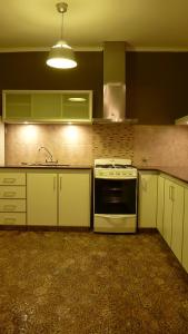 拉普拉塔Casa con garage y patio - 6 personas - 26 y 45的厨房配有白色橱柜和炉灶烤箱。