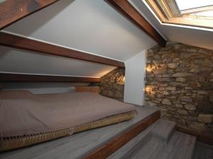 圣拉斐尔Maison Vauban Plus的一间卧室设有一张床和石墙