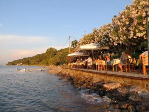 布卡里阿克吉利旅馆的一群人坐在水边的餐厅里