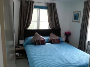 圣沃尔夫冈沙夫山公寓 的一间卧室配有一张带蓝色床单的床和一扇窗户。