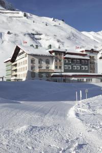 祖尔斯雪绒花酒店的山前大雪中的一座大建筑