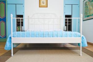 费尔莫拉卡萨德尔阿提斯塔酒店的蓝色墙壁的客房内的一张白色床