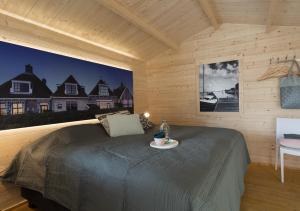玛库姆Lodgehotel de Lelie的木制客房内的一间卧室,配有一张床