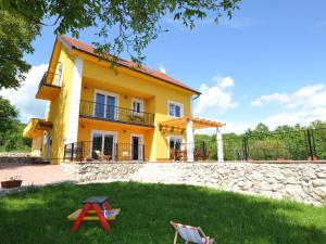 PocrnjaLuxurious Villa in Tijarica with a Private Pool的黄色的房子,带两把椅子的院子