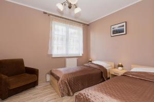 斯维诺乌伊希切Apartamenty Villa Park by Renters的一间卧室设有两张床、一把椅子和一个窗户。