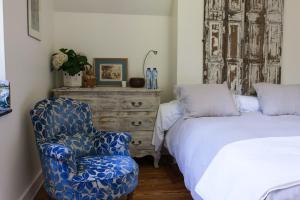 斯帕布瓦多蒙特住宿加早餐酒店的一间卧室配有一张床、一把椅子和一个梳妆台