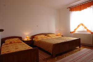 伦Apartmani Vesna的一间卧室设有两张床和窗户。