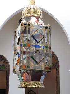 丹吉尔阿鲁斯卡梅尔摩洛哥传统庭院旅馆的挂在天花板上的彩色玻璃吊灯
