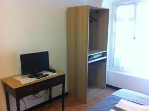 热那亚潘森酒店的一间配备有一张书桌的房间,电脑在里面