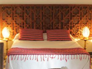 丹吉尔阿鲁斯卡梅尔摩洛哥传统庭院旅馆的床上有两张红色条纹枕头