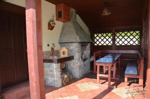 切尔韦尼克拉什托尔Penzión pod Troma Korunami的厨房配有石制壁炉、桌子和木桌四柱四柱床