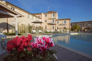 卡麦奥雷Il Tremarino的一座别墅,设有游泳池和粉红色的鲜花