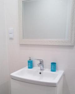尤斯托尼莫斯基Apartament Ku Morzu II Ustronie Morskie的浴室水槽和两个蓝色杯子