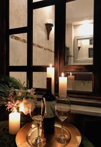 康塞普西翁德阿塔科Casa Degraciela - Hotel Boutique的一张桌子,上面放着两杯葡萄酒和蜡烛