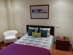 大加那利岛拉斯帕尔马斯Casa Cafer的一间卧室配有一张床和一张白色椅子