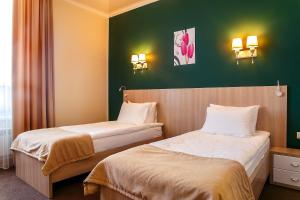 阿斯塔纳AYKUN Hotel by AG Hotels Group的绿墙旅馆客房的两张床