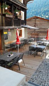NiederwaldHotel-Restaurant Drei Tannen的大楼内带桌椅的木制甲板
