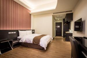 Xiluo米都商务饭店的配有一张床和一台平面电视的酒店客房