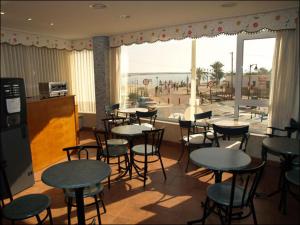 洛帕莞洛斯莫利诺斯酒店的一间带桌椅的餐厅,享有海滩美景