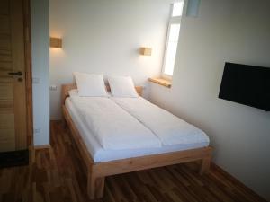 卡尔克尔Klevas的一间卧室配有一张带白色床单的床和一扇窗户。