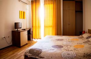 拉夫达Ivatea Family Hotel的一间卧室配有一张床、一台电视和一个窗口