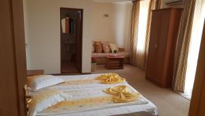 阿赫洛伊Guest House Markovi Aheloy的一间卧室配有两张带黄毛巾的床。