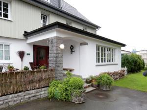 温特贝格Comfortable Holiday Home in Neuastenberg的一间白色的房子,有红色的门和栅栏