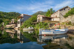 KaručParadise House Skadar Lake的坐在建筑物旁边的水中的小船