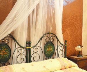 帕基诺B&B TascaPachino的一间卧室配有一张带天蓬和窗帘的床