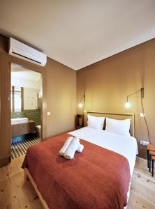 波尔图Aparthotel Oporto Batalha的酒店客房设有一张大床和一间浴室。