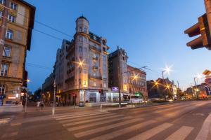 布达佩斯Hotel Golden Park Budapest的一条空荡荡的城市街道,在晚上有一座大建筑