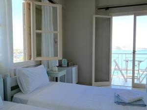 皮洛斯12 Gods Resort的一间白色卧室,配有床和阳台