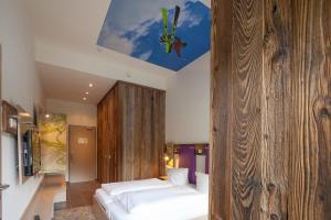 茵特斯托德Explorer Hotel Hinterstoder的一间卧室设有一张床和木墙