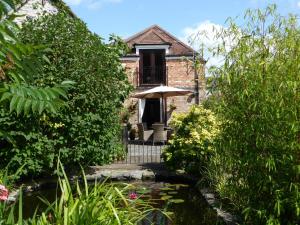 IlchesterLiongate House的房屋前带池塘的花园