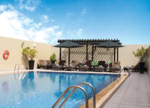 迪拜阿尔巴沙奥酷瑞公寓式酒店的一个带椅子和遮阳伞的大型游泳池
