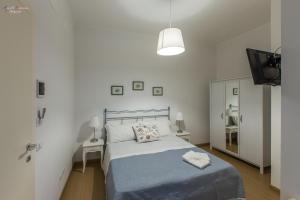 恩纳B&B A Casa dei Nonni的一间白色卧室,配有床和电视